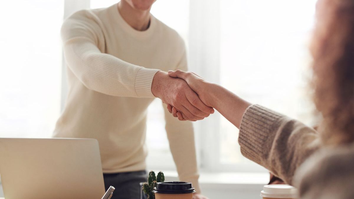 Recruiter and newly qualified teacher shaking hands after a successful job search
