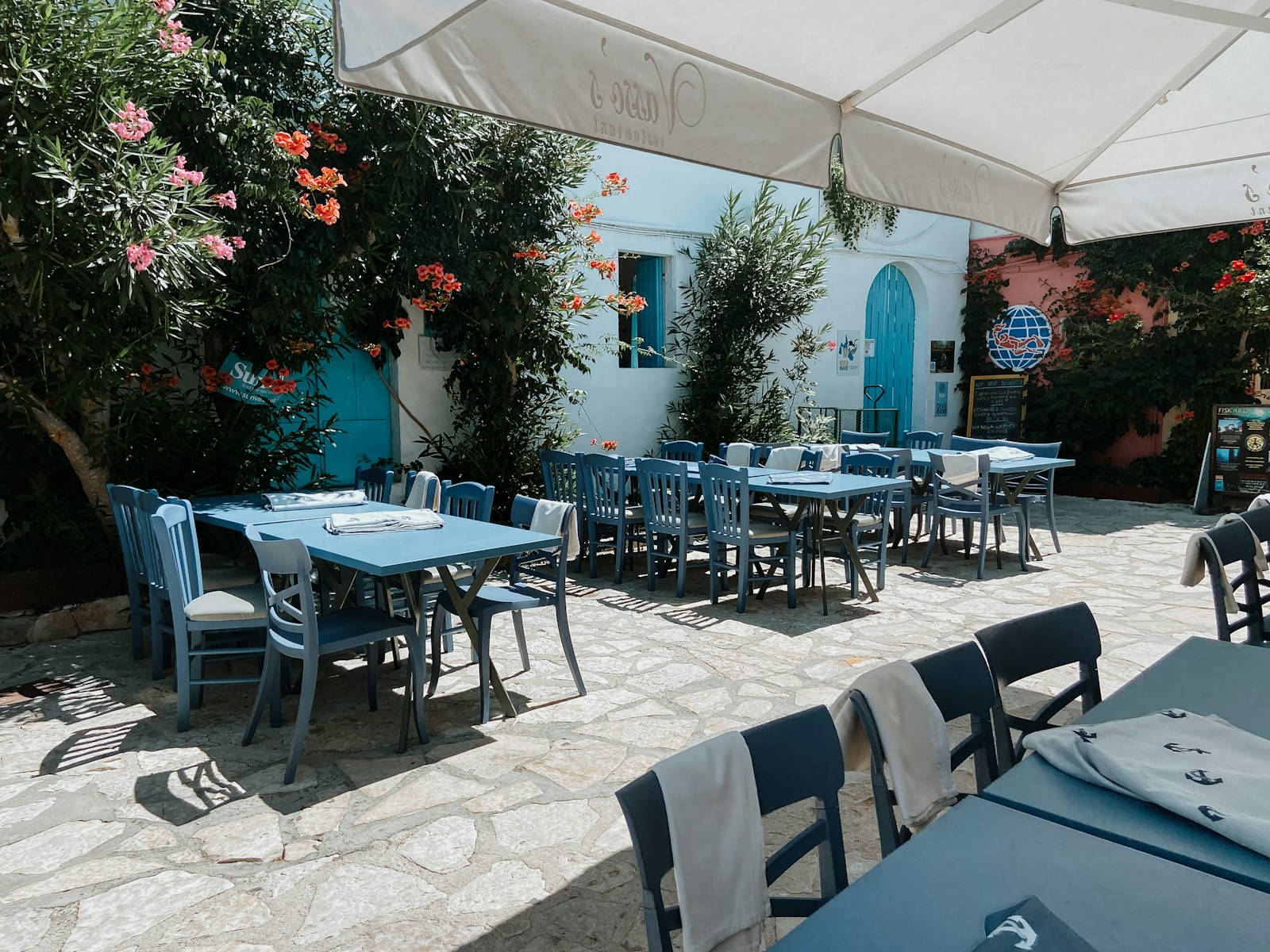 Outdoor taverna tables in a Greek town, where eating out costs far less than in the UK or Ireland