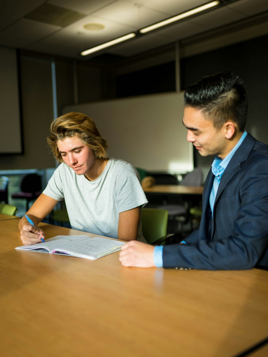 An early career teacher and their induction mentor reviewing progress in a one to one meeting