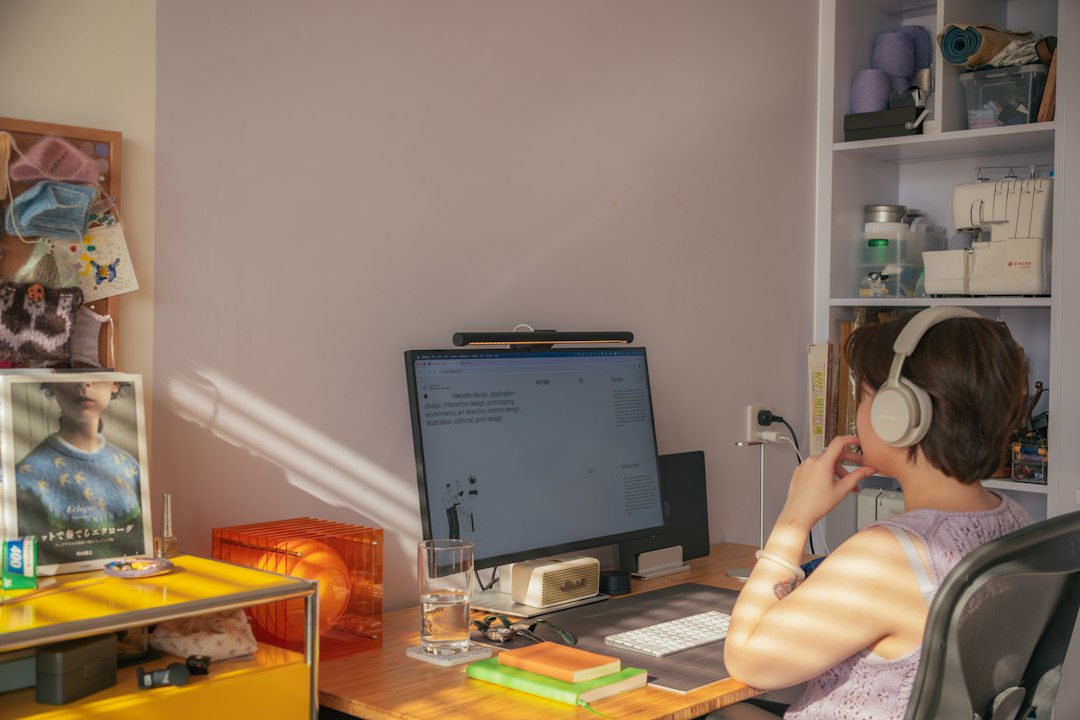 Online English teacher at a home desk with a headset and computer, the setup Novakid applicants need