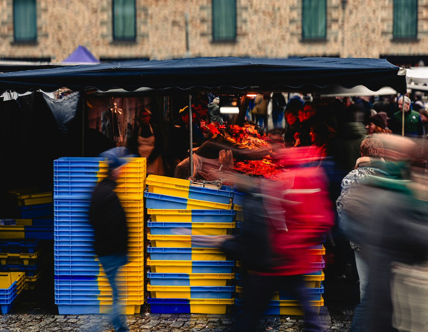 Busy outdoor market stall in Rennes, where English teachers in France keep food costs down