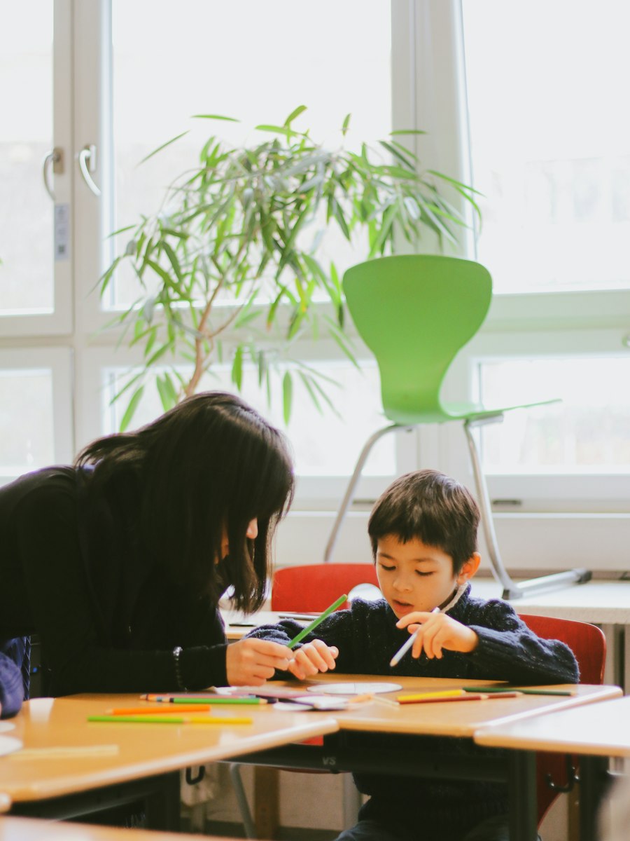 Teacher helping a limited English proficient LEP student one to one at a table