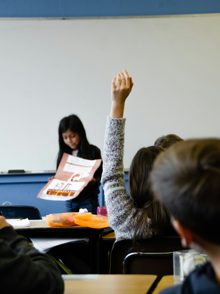 English learner student raising her hand in a US school classroom lesson
